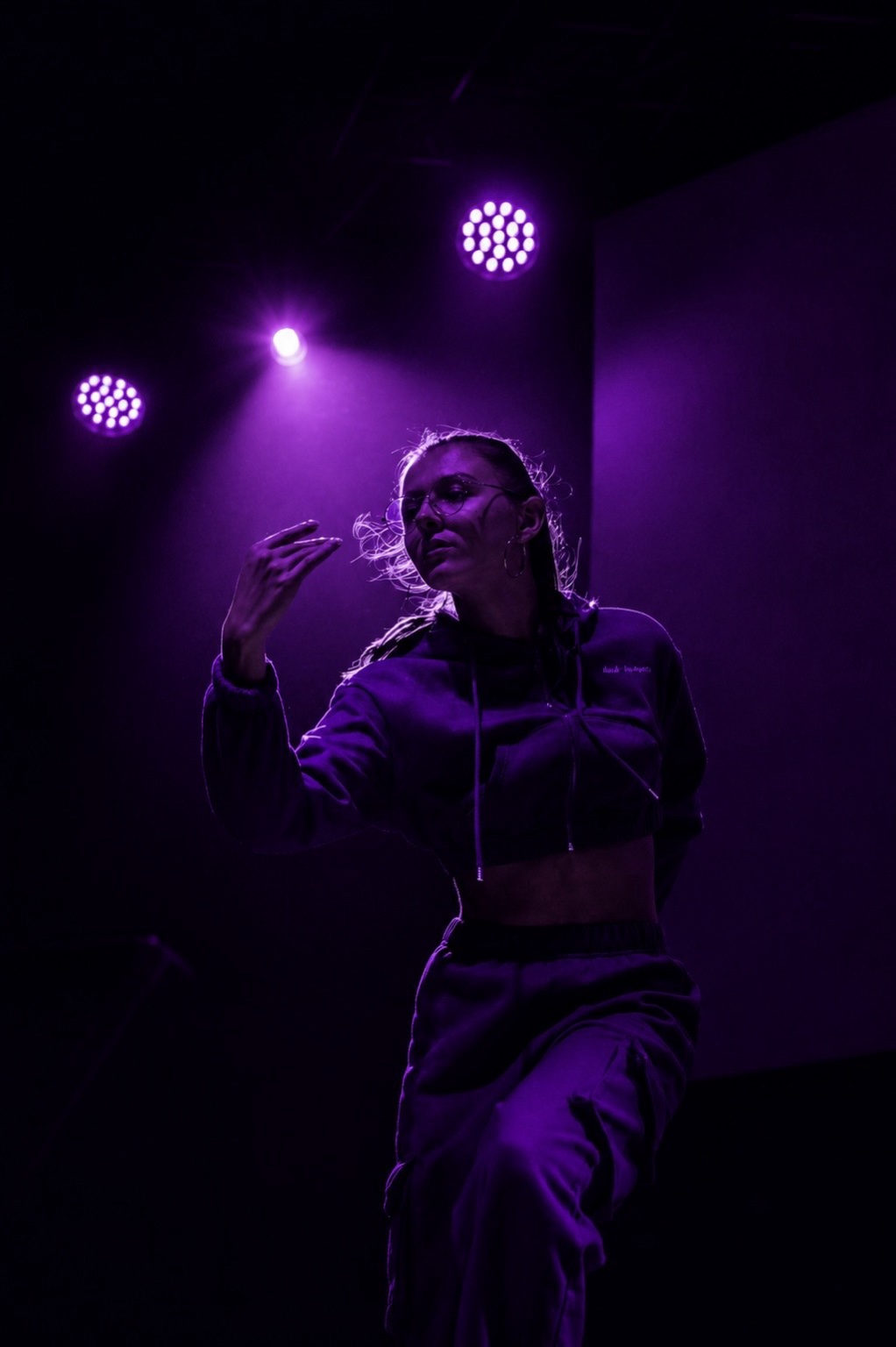 Laurie danse sous les lumières violettes d’une scène